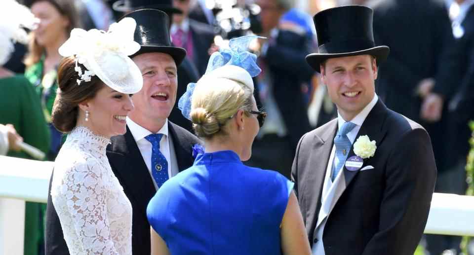 Kate Middleton rit en portant une robe en dentelle blanche.  Elle parle à Zara et Mike Tindall et son mari, le prince William.  (Getty Images)