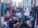 Les partisans du Freedom Convoy bloquent les routes et les trottoirs de la colline du Parlement pour protester contre les mandats et les restrictions du vaccin COVID-19 à Ottawa le 29 janvier 2022.