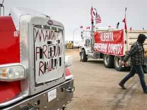 Des manifestants anti-mandat se rassemblent alors qu'un convoi de camions bloque l'autoroute du passage frontalier américain très fréquenté à Coutts, en Alberta, le lundi 31 janvier 2022.