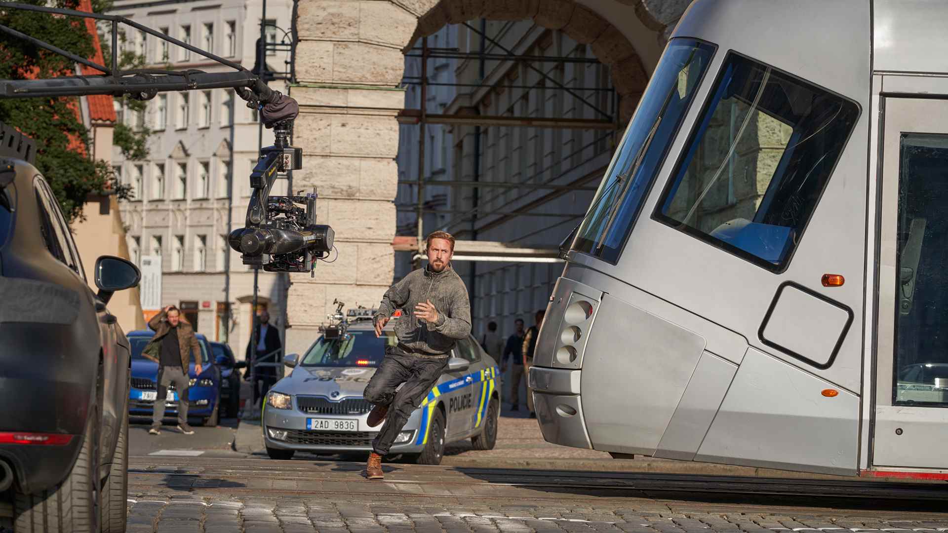 Une photo des coulisses de la Sierra Six de Ryan Gosling passant devant un tramway pendant qu'une caméra le remplit dans The Grey Man