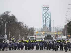 La police fait la queue pour expulser tous les camionneurs et sympathisants à Windsor, en Ontario, le dimanche 13 février 2022.