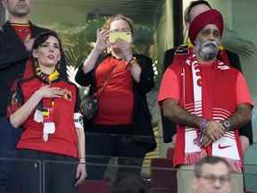 Le ministre canadien du Développement international, Harjit Sajjan, à droite, se tient debout pendant les hymnes nationaux avant le match de la coupe du monde entre la Belgique et le Canada à Doha, au Qatar, le 23 novembre 2022. Le ministre belge des Affaires étrangères Hadja Lahbib, portant un "One Love" brassard, est sur la gauche.