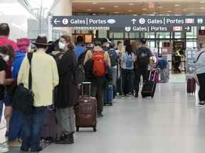 Les gens font la queue avant d'entrer dans la sécurité de l'aéroport international Pearson de Toronto le 5 août 2022.