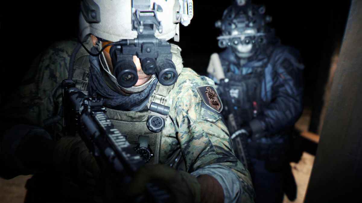 Deux soldats marchent dans une pièce faiblement éclairée.  L'un a une lampe frontale allumée avec une lunette intégrée. 