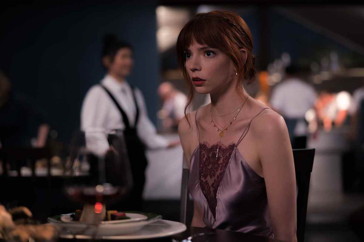 Margo (Anya Taylor-Joy), une jeune femme vêtue d'une robe à fines bretelles transparente, regarde quelque chose hors écran avec une expression horrifiée dans The Menu