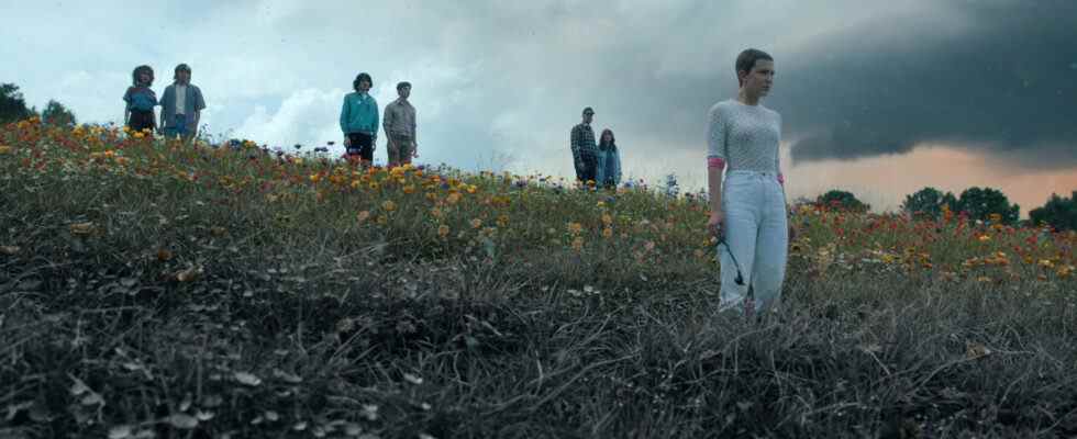 STRANGER THINGS. (L to R) Natalia Dyer as Nancy Wheeler, Charlie Heaton as Jonathan Byers, Finn Wolfhard as Mike Wheeler, Noah Schnapp as Will Byers, David Harbour as Jim Hopper, Winona Ryder as Joyce Byers, and Millie Bobby Brown as Eleven all stand in a field overlooking Hawkins in the season 4 part 2 finale