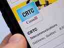 Une personne navigue sur la page des médias sociaux du Conseil de la radiodiffusion et des télécommunications canadiennes (CRTC) sur un téléphone cellulaire à Ottawa le lundi 17 mai 2021. 