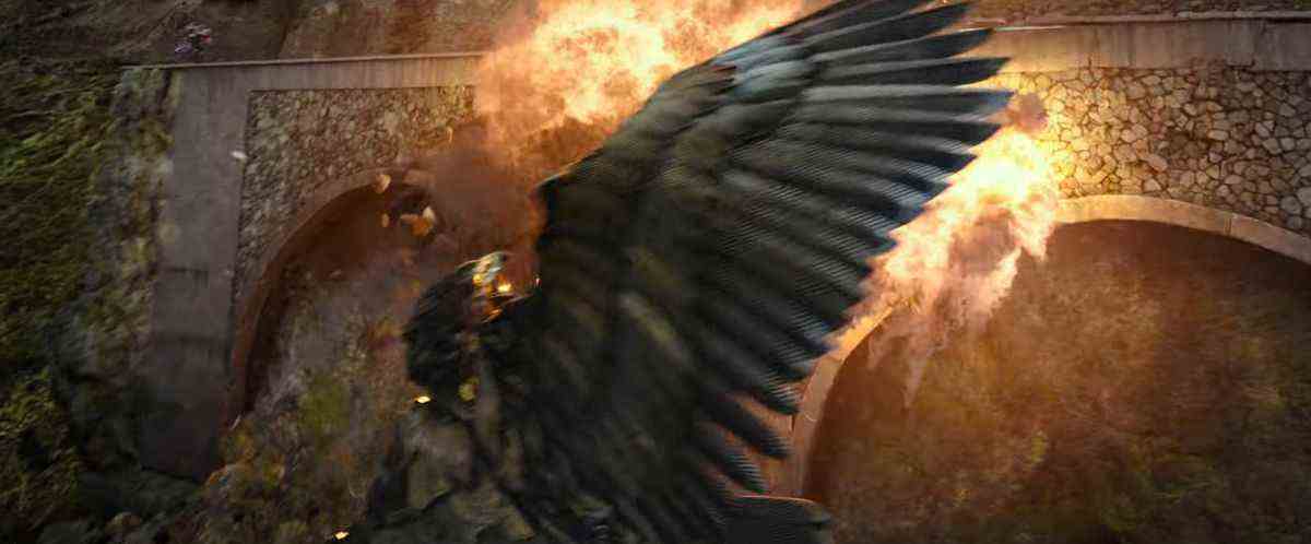 Arizor l'oiseau Transformer fonce autour d'une explosion sur un pont dans Transformers: Rise of the Beasts