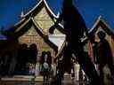 Un groupe de touristes passe devant un temple en Thaïlande.  Le pays fait partie des pays sur lesquels les investisseurs peuvent vouloir se concentrer.