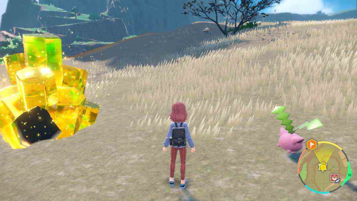 Le joueur de Pokémon Scarlet se tient entre un cristal jaune étincelant, qui marque un Tera Raid, et le Pokémon Hoppip rose en forme de plante.