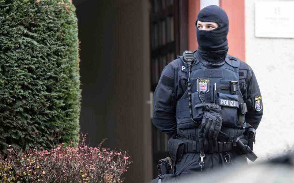 Des policiers se tiennent près d'une propriété fouillée à Francfort lors d'un raid contre les soi-disant « citoyens du Reich » à Francfort – Boris Roessler/dpa via AP