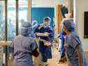 Des infirmières qui attendent à l'extérieur de la salle d'isolement aident l'équipe travaillant à l'intérieur de la salle d'isolement d'un patient atteint de la maladie à coronavirus (COVID-19) à l'intérieur de l'unité de soins intensifs de l'hôpital Humber River à Toronto, Ontario, Canada le 15 avril 2021. Photo prise le 15 avril 2021 . REUTERS/Carlos Osorio ORG XMIT : GGG-TOR125