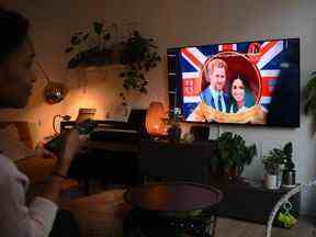 Une femme regarde un épisode de Harry & Meghan sur le duc et la duchesse de Sussess, le prince Harry et Meghan Markle le 8 décembre 2022. Daniel Leal / Agence-France Presse