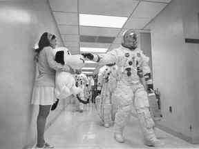 Touche de chance : le secrétaire Jamye Flowers tient un Snoopy en peluche alors que l'astronaute Thomas Stafford se dirige vers Apollo 10 pour le lancement.
