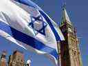 Le drapeau israélien flotte avec la Tour de la Paix en arrière-plan sur la Colline du Parlement à Ottawa le 21 avril 2002. 
