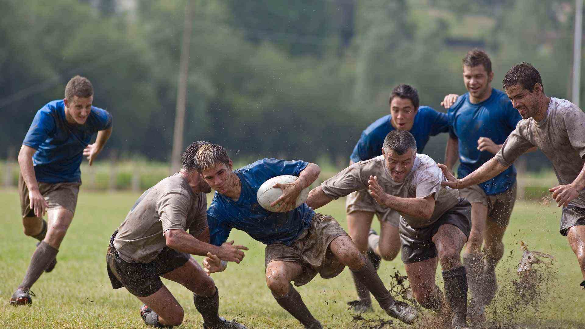 image d'hommes jouant au rugby s'affrontant sur un terrain