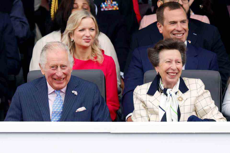 Le roi Charles III et la princesse Anne rient en s'asseyant l'un à côté de l'autre.  (Getty Images)