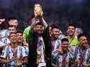 Le capitaine et attaquant argentin # 10 Lionel Messi (C) soulève le trophée de la Coupe du monde de la FIFA sur scène alors qu'il célèbre avec ses coéquipiers après avoir remporté le match de football final de la Coupe du monde Qatar 2022 entre l'Argentine et la France au stade Lusail à Lusail, au nord de Doha en décembre 18, 2022.