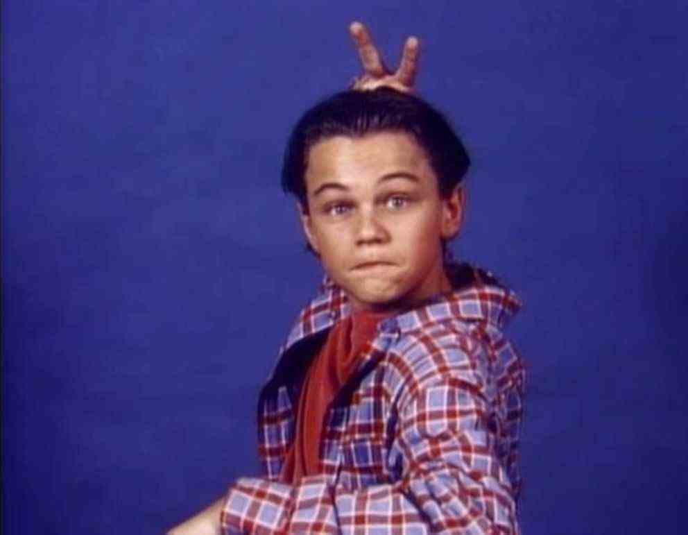 Le jeune Leonardo Dicaprio vêtu d'un plaid rouge et bleu se donnant des oreilles de lapin dans Growing Pains