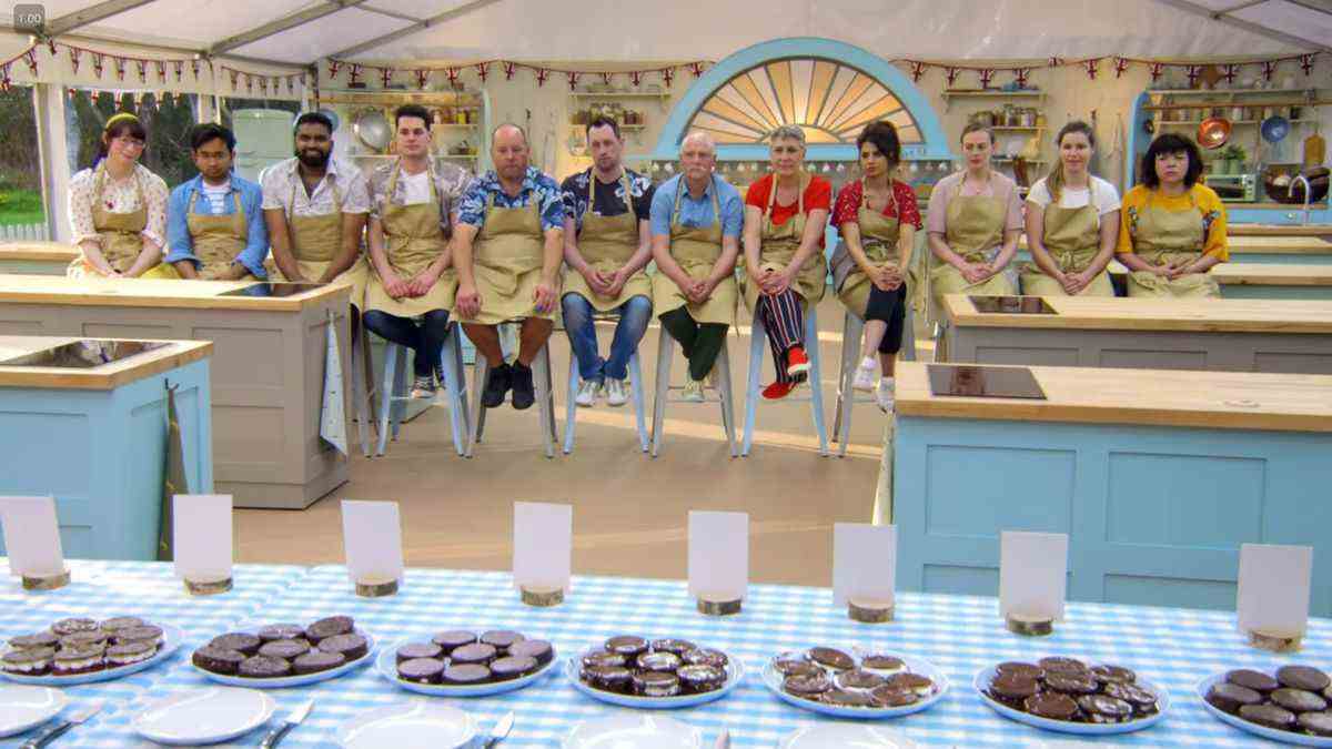 Le casting de Great British Bake Off saison 9 assis dans une rangée lors du jugement d'un défi technique où on leur a demandé de cuire des roues de wagon.