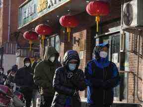 Des résidents portant des masques font la queue pendant une journée froide devant une pharmacie pour acheter des médicaments en vue d'une éventuelle vague d'épidémies de COVID-19 à Pékin, le mardi 13 décembre 2022.