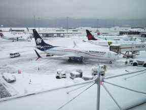Des aéronefs sont vus stationnés aux portes de l'aéroport international de Vancouver après une tempête de neige ayant entraîné des annulations et des retards importants, à Richmond, en Colombie-Britannique, le mardi 20 décembre 2022.