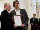 (FICHIERS) Dans cette photo d'archive prise le 29 mai 2012, le président russe Vladimir Poutine (R) détient un certificat, ainsi que le membre de l'équipe nationale russe de hockey sur glace Alexander Ovechkin (2e L), remerciant Ovechkin pour ses efforts pour aider la Russie à gagner le Championnat du monde 2012.