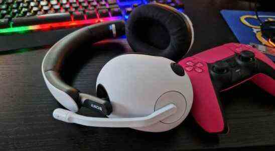 Sony Inzone H7 Review image with headset lying horizontal on a desk, next to a Pink Dualsense controller