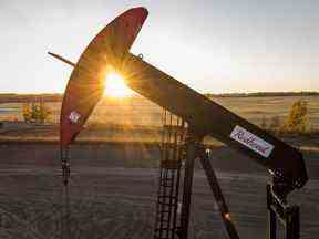Un pumpjack extrait du pétrole et du gaz d'une tête de puits alors que le soleil se couche près de Calgary, en Alberta, le dimanche 9 octobre 2022.