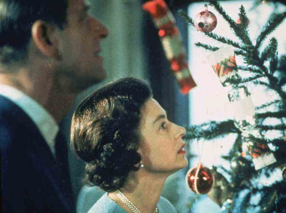 Juin 1969 : la reine Elizabeth II et le prince Philip regardent leur sapin de Noël décoré lors du tournage d'une émission spéciale sur la vie dans la famille royale britannique.  (Photo par Fox Photos/Getty Images)