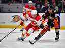 Le défenseur des Flames de Calgary Rasmus Andersson (4) déplace la rondelle contre l'ailier droit des Ducks d'Anaheim Brett Leason (20) au cours de la troisième période au Honda Center le 23 décembre 2022 à Anaheim, Californie, États-Unis.