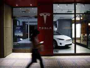 Un piéton passe devant un magasin Tesla Inc. à Palm Desert, en Californie.