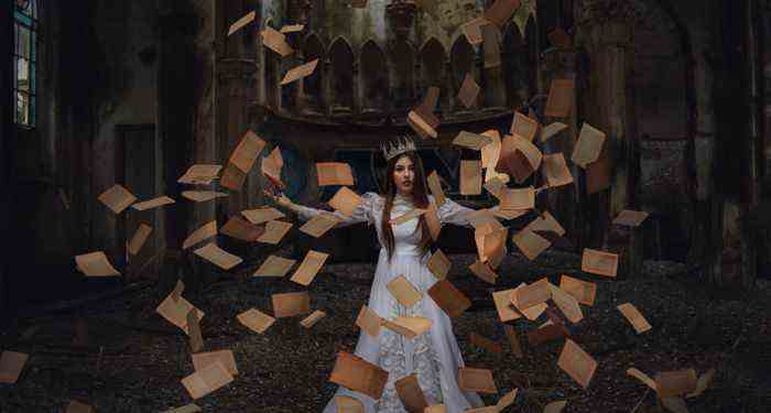 femme à la peau plus claire avec couronne et les pages d'un livre en l'air