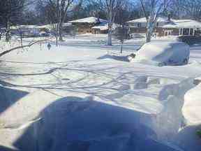 Une voiture est recouverte de neige dans une allée, dimanche 25 décembre 2022, à Amherst, NY