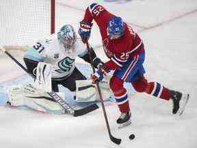 Ryan Poehling des Canadiens de Montréal rejoint le gardien de but du Seattle Kraken Philipp Grubauer lors de la première période de hockey de la LNH à Montréal, le samedi 12 mars 2022.