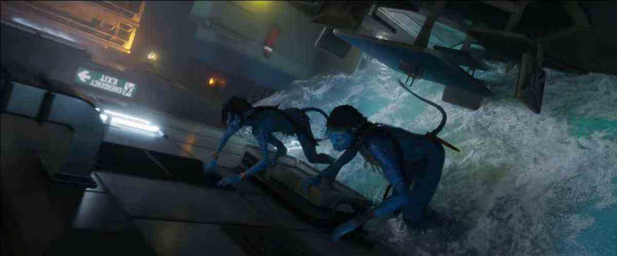Deux Navi bleus fuient la montée des eaux dans une structure en train de couler dans Avatar: The Way of Water