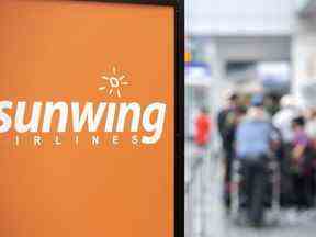 Des voyageurs font la queue à un comptoir d'enregistrement de Sunwing Airlines à l'aéroport Trudeau de Montréal, le mercredi 20 avril 2022.