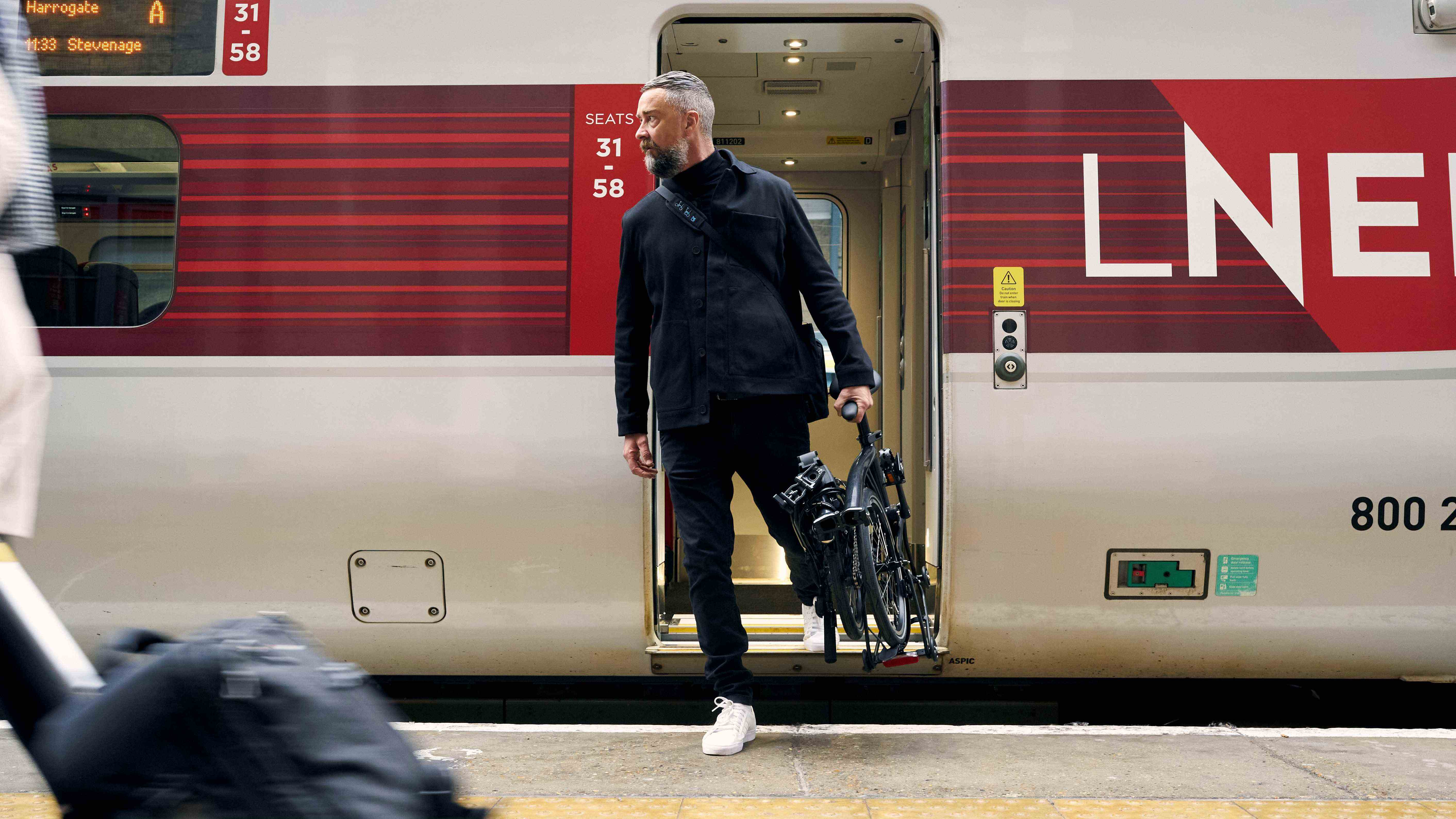 une photo d'un homme descendant d'un train transportant la ligne électrique P de Brompton