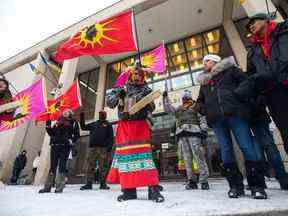 Sue Caribou, au centre, chante une chanson devant l'hôtel de ville de Winnipeg lors d'un rassemblement, le jeudi 15 décembre 2022, pour demander à la ville de cesser les opérations de déversement dans une décharge et de rechercher les restes d'Autochtones disparus et assassinés les femmes qu'on croit être là.