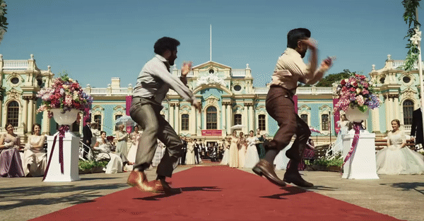Bheem et Ram dansent sur un tapis rouge devant un palais anglais