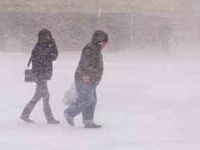 Des piétons marchent dans des conditions de type blizzard à Brantford, en Ontario, le 23 décembre 2022.