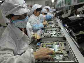 Ouvriers chinois de l'usine Foxconn qui fabrique des iPhones à Shenzhen, dans la province du Guangdong, dans le sud de la Chine.