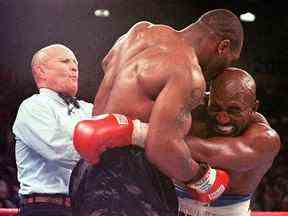 Cette photo d'archive du 28 juin 2007 montre l'arbitre Lane Mills (L) intervenant alors qu'Evander Holyfield (R) réagit après que Mike Tyson (C) se soit mordu l'oreille au troisième tour de leur combat de championnat WBA Heavyweight au MGM Grand Garden Arena de Las Vegas .