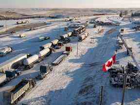 Un convoi de camions de manifestants du mandat du vaccin anti-COVID-19 bloque l'autoroute au passage frontalier achalandé entre le Canada et les États-Unis à Coutts, en Alberta, le mercredi 2 février 2022.