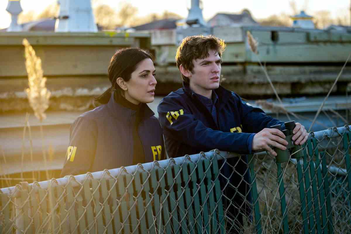 Deux agents du FBI dans Kaleidoscope de Netflix se tiennent debout sur une clôture
