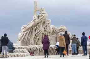 Les visiteurs de Port Stanley se rassemblent pour admirer les plumes de glace ornant cette créature émergeant du lac Érié sur la jetée sur une photo prise par Derek Ruttan du London Free Press le 26 décembre 2022.