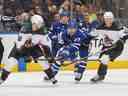 Pierre Engvall des Maple Leafs de Toronto se bat pour la rondelle entre JJ Moser et Troy Stecher des Coyotes de l'Arizona lors d'un match de la LNH au Scotiabank Arena le 17 octobre 2022 à Toronto, Ontario, Canada.