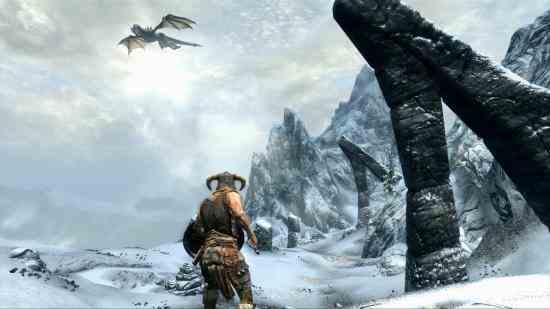 Meilleurs jeux de Noël - le Dovakin regarde un dragon volant haut dans les montagnes dans The Elder Scrolls V: Skyrim.