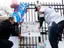 Les fans de football collent un panneau sur une clôture lors d'une veillée le mardi 3 janvier 2022, à l'extérieur du centre médical de l'Université de Cincinnati où Bills Safety Damar Hamlin se trouve dans un état critique, après avoir subi un arrêt cardiaque lors du match du lundi 2 janvier contre les Bengals, à Cincinnati.