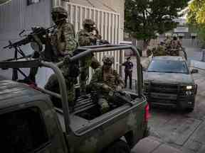 Des véhicules blindés quittent le bureau du procureur général chargé des enquêtes spéciales sur le crime organisé (FEMDO) à Mexico, le 5 janvier 2023, après l'arrestation d'Ovidio Guzman.